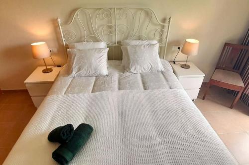 a bedroom with a white bed with two pillows at APARTAMENTO PLAYA FOZ in Foz