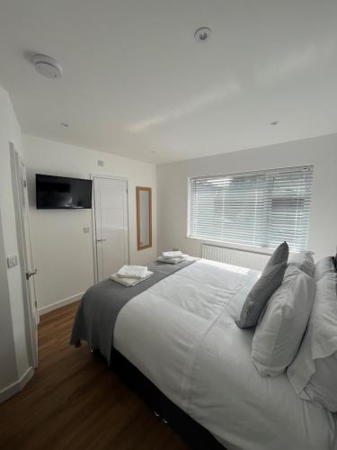 1 cama blanca grande en un dormitorio con ventana en The Annexe en Felton