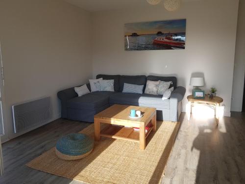 a living room with a couch and a coffee table at Au cœur du Bassin d'Arcachon in Gujan-Mestras