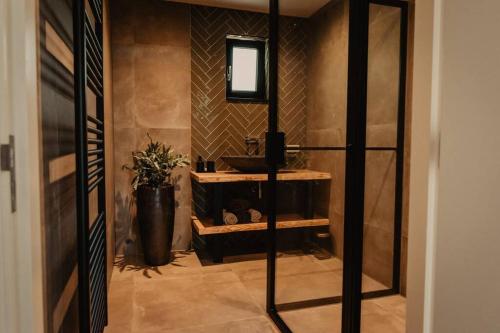 ein Bad mit einem Waschbecken und einem Spiegel in der Unterkunft Luxe schuurwoning 't Nieuwt in Chaam, Nederland in Chaam
