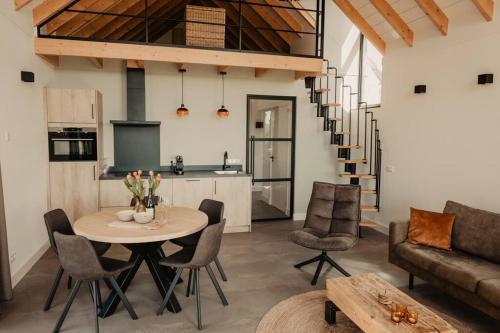 eine Küche und ein Wohnzimmer mit einem Tisch und Stühlen in der Unterkunft Luxe schuurwoning 't Nieuwt in Chaam, Nederland in Chaam