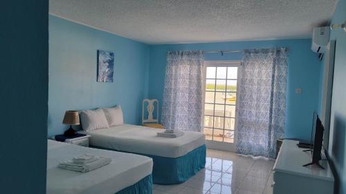 a blue room with two beds and a television at Fisherman's Inn in Florence Hall