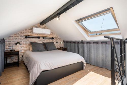 蓋亞的住宿－Superbe Loft industriel - Casa Vostra - Gaillard Tram-Frontière，一间卧室设有一张床和砖墙