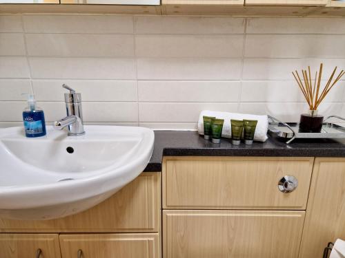 a bathroom with a sink and a black counter at Stunning Luxury Serviced Apartment next to City Centre with Free Parking - Contractors & Relocators in Coventry