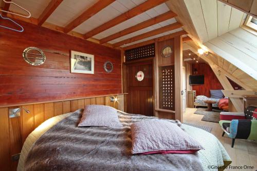 a bedroom with a bed in a room with wooden walls at Les Insolites de Coco in La Lande-de-Goult