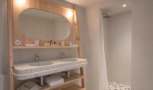 y baño con lavabo y espejo. en Hotel des Dunes, en Cap-Ferret