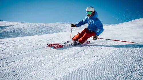 una persona está esquiando por una pista cubierta de nieve en Apartamento San Roque Villablino, en Villablino
