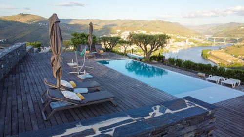 una piscina con sedie e ombrelloni sul tetto di Quinta Pecêga - AL a Peso da Régua