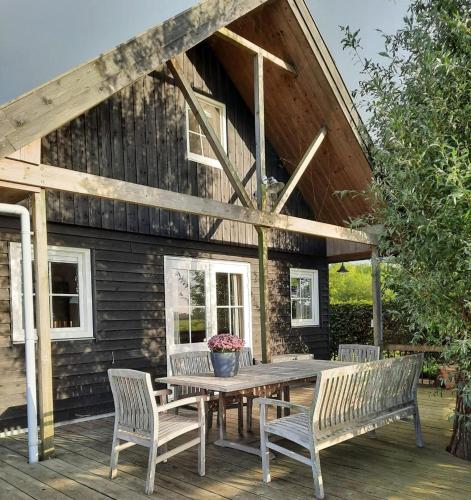 a wooden table and chairs on a wooden deck at Vakantiehuisjes Marsherne in Poppingawier