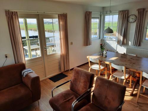 a living room with a dining room table and chairs at Vakantiehuisjes Marsherne in Poppingawier