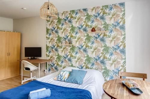 1 dormitorio con 1 cama con papel pintado tropical en Friendly Studio Orsay - Near Schools & Businesses, en Orsay