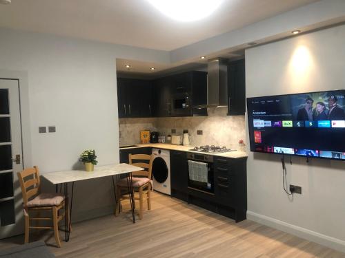 a kitchen with a large tv on the wall at Royal Mile Famous Canongate Flat in Edinburgh