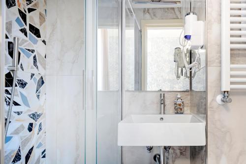 La salle de bains est pourvue d'un lavabo et d'une douche. dans l'établissement Joyful Termini Boutique Guest House, à Rome