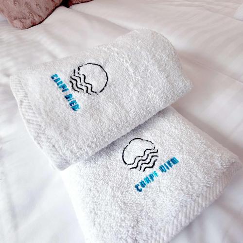 two towels sitting on top of a bed at Carpe Diem Lakeside Suite Apartments in Szczecin
