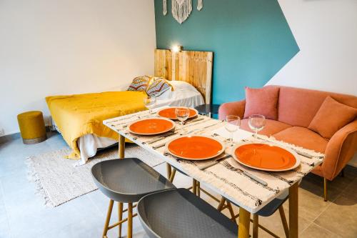 a living room with a table and a couch at Le Sunset, Magnifique Studio pieds dans l'eau, L'Ermitage les Bains in Filaos