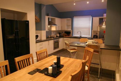 a kitchen with a wooden table and a dining room at Comfy big 7 bedroom townhouse in Harrogate