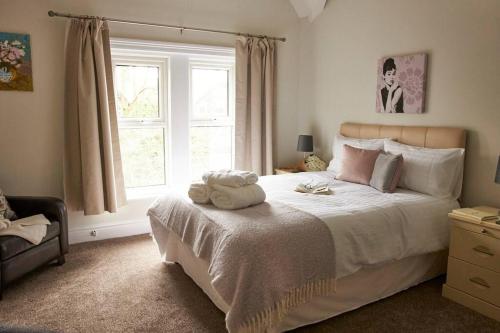 a bedroom with a large white bed with a window at Comfy big 7 bedroom townhouse in Harrogate