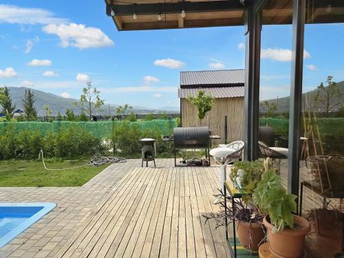 a wooden deck with a grill and a pool at Eco Saguramo Chalet in Saguramo