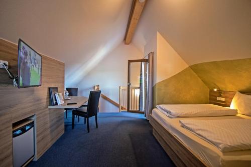 a hotel room with a bed and a desk with a computer at Hotel Klosterbräustuben in Zell am Harmersbach