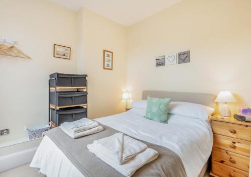 um quarto com uma cama com toalhas em Breaker Apartment em Southwold