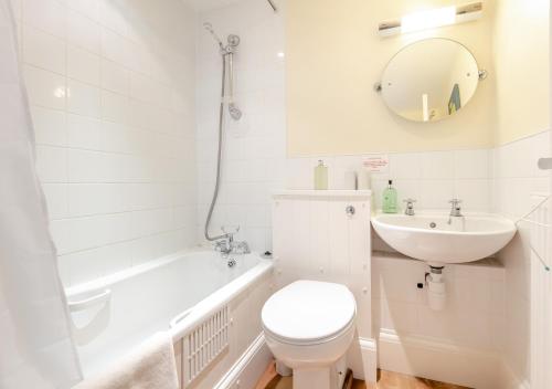 uma casa de banho branca com um WC e um lavatório em Breaker Apartment em Southwold