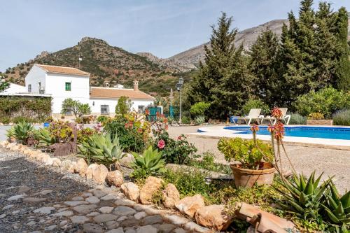a garden in front of a house with a swimming pool at Alojamiento Rural el Viso in El Chorro