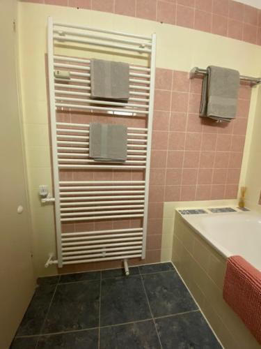 a bathroom with a tub and a towel rack at Apartment Skischanze in Garmisch-Partenkirchen