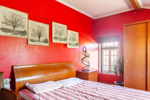 1 dormitorio con una pared roja y 1 cama en B&B Quarto Vermelho Estilo Moderno, 