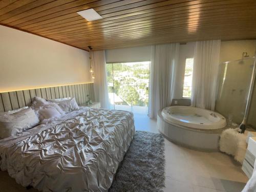 a bedroom with a bed and a bath tub at Chalé lindo para toda família nas montanhas !!! in Domingos Martins