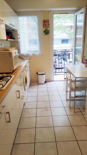 Il comprend une cuisine dotée de carrelage blanc et d'une table. dans l'établissement T2 full centre at 7 min from the beach, à Arcachon