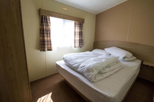 מיטה או מיטות בחדר ב-Superb 8 Berth Caravan Near Walton-on-the-naze In Essex Ref 17175