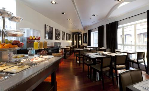 um restaurante com mesas e cadeiras e um bufê em Quatro Puerta del Sol em Madrid
