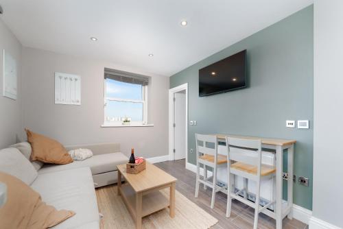 a living room with a couch and a table at Cosy Retreat with Views of Brighton City and Sea in Brighton & Hove