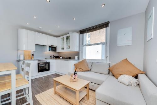 a living room with a couch and a table at Cosy Retreat with Views of Brighton City and Sea in Brighton & Hove