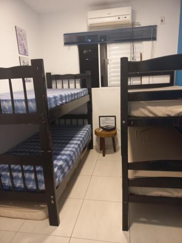 a room with three bunk beds and a fan at Casa Oceano Azul in Guarujá