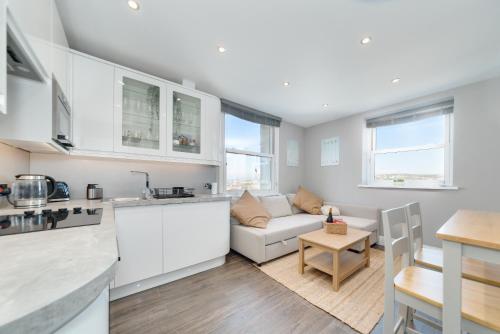 a kitchen and living room with a couch and a table at Cosy Retreat with Views of Brighton City and Sea in Brighton & Hove