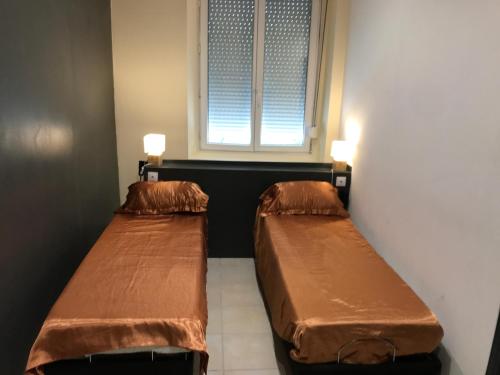 2 camas en una habitación con ventana en Sci ZLR en Saint-Étienne