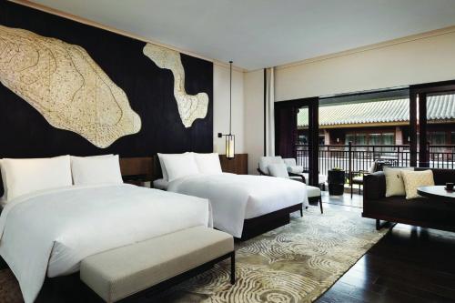 um quarto de hotel com duas camas e um sofá em JW Marriott Hotel Qufu em Qufu