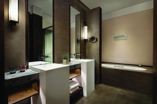 uma casa de banho com 2 lavatórios e um espelho grande em JW Marriott Hotel Qufu em Qufu