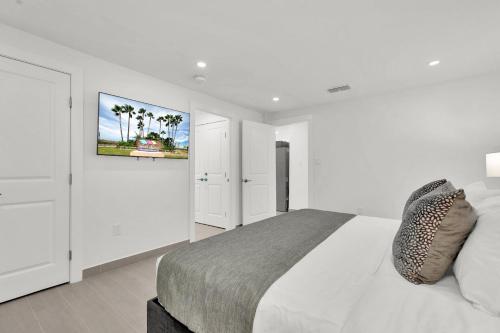 een witte slaapkamer met een bed en een schilderij aan de muur bij Spectacular Ocean-View Condo in Beachfront Resort in South Padre Island