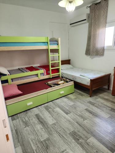 een kamer met 2 stapelbedden en een houten vloer bij Бат-ям 2-ком. Квартира аренда!!! in Bat Yam