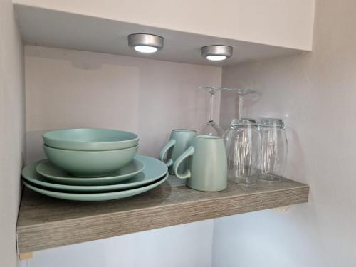 a shelf with bowls and plates on it at Bunny Lodge - Garden view & free parking in Plumtree