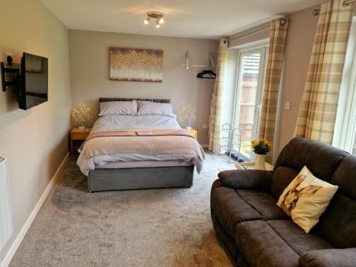 a bedroom with a bed and a couch at Bunny Lodge - Garden view & free parking in Plumtree