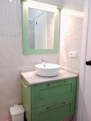 a bathroom with a green cabinet with a sink at Atico en La Ría in Viveiro