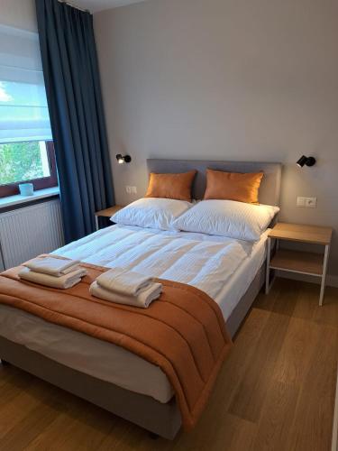a bedroom with a large bed with two towels on it at Pokoje De Luxe Figaro in Płock