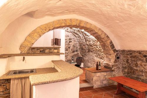 una cucina con parete in pietra e piano di lavoro di domo historica sedini a Sedini