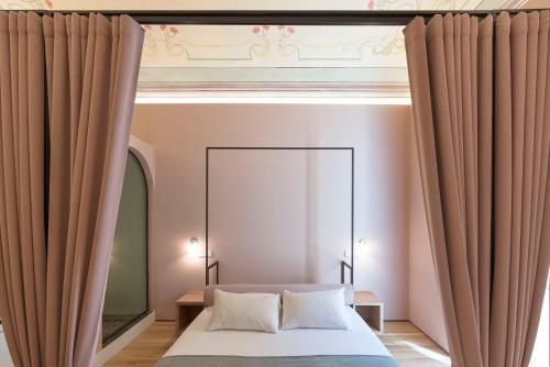 a bedroom with a bed with curtains and a mirror at FilHome 44 in Catania