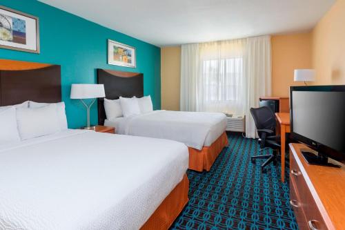 a hotel room with two beds and a flat screen tv at Fairfield Inn & Suites Corpus Christi in Corpus Christi