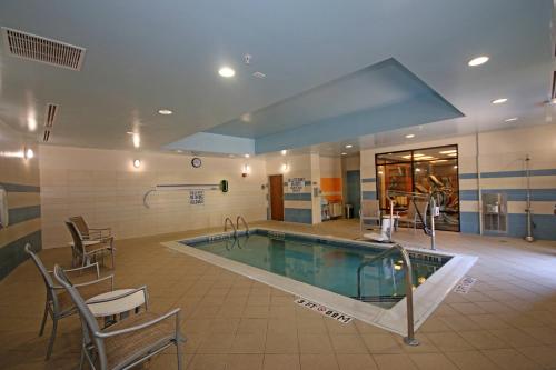 a swimming pool in a building with chairs around it at SpringHill Suites by Marriott Charleston North in Charleston