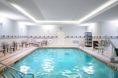 una piscina en un spa con sillas y mesas en Courtyard by Marriott Denton, en Denton